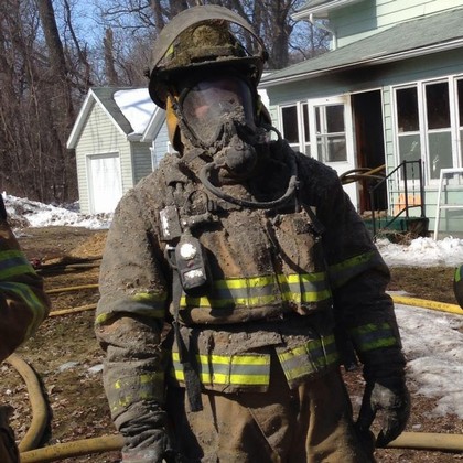 Firefighter covered in soot from house fire
