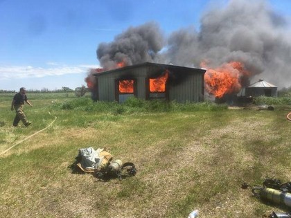 building in a field on fire
