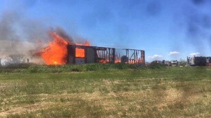 building in a field on fire