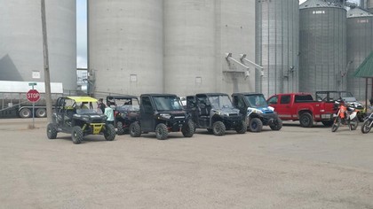 line of four wheelers and one red truck