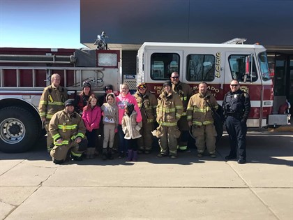Girl Scouts and Firefighters in front of red firetruck 