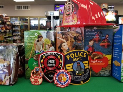 Police & Fire department badges in front of Girl Scout cookie boxes