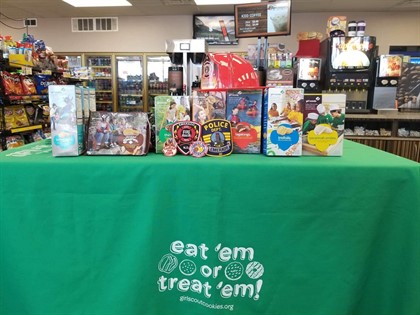 Green girl scout table with girl scout cookie boxes on top